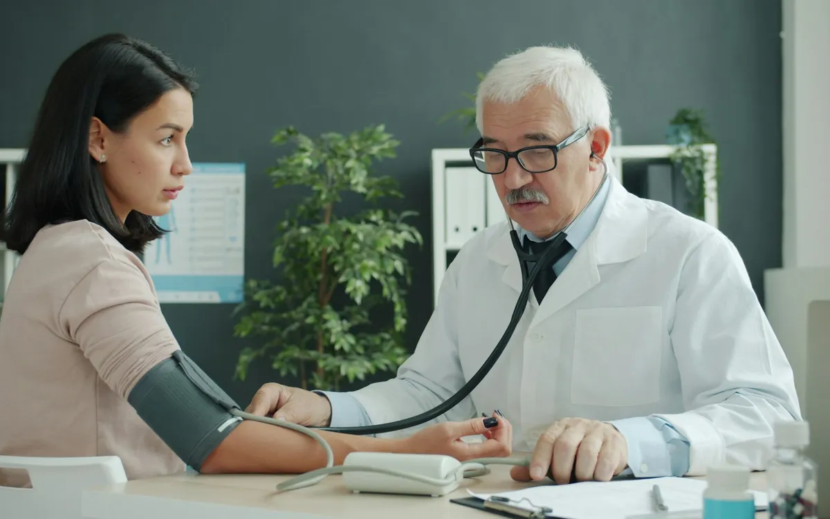 Médico medindo a pressão de um paciente com estetoscópio