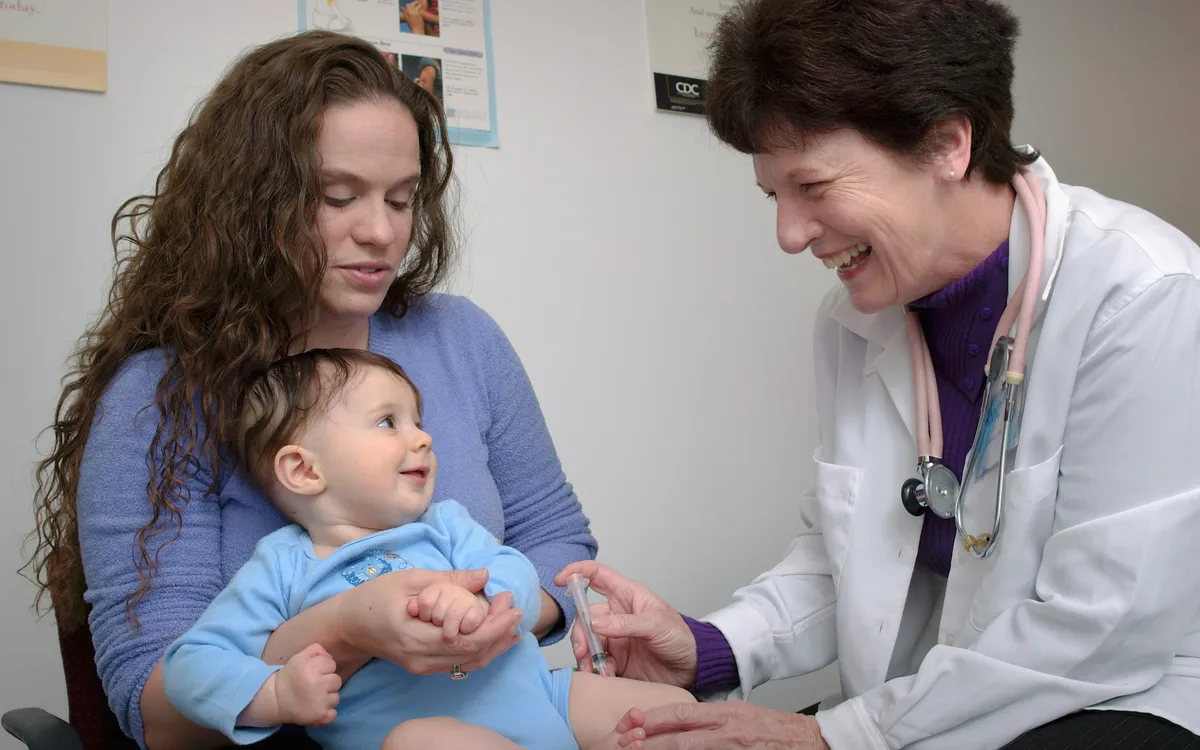 Criança pequena sendo examinada pela médica