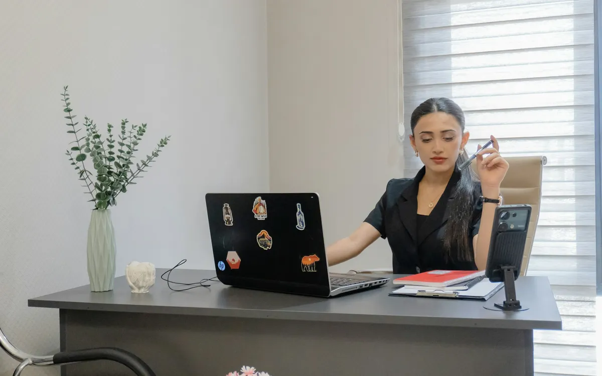 Mulher trabalhando na mesa com notebook e celular