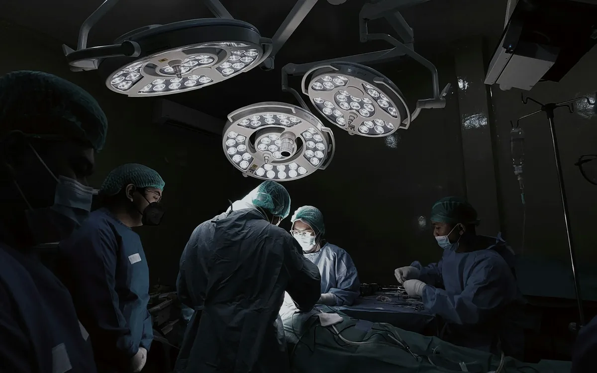 Médicos reunidos ao redor de um leito de hospital