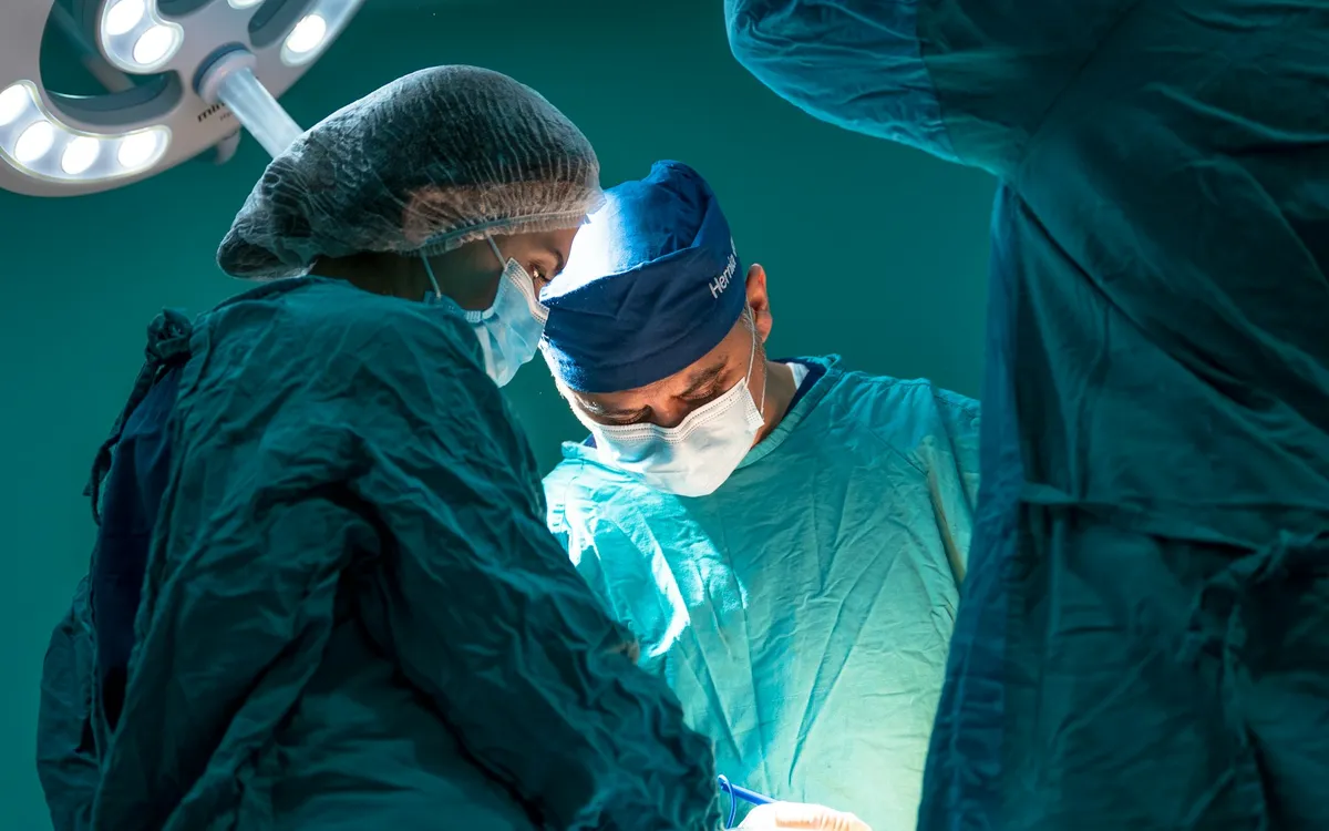 Médicos em volta de um paciente durante uma operação