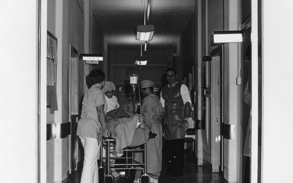 Equipe médica levando um paciente pelo corredor do hospital