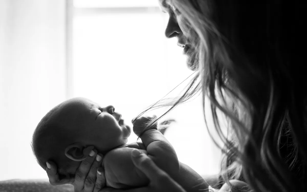 Mãe segurando o bebê recém-nascido no colo