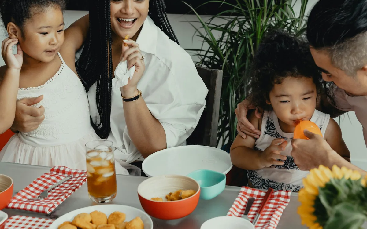 Família comendo junto à mesa em casa