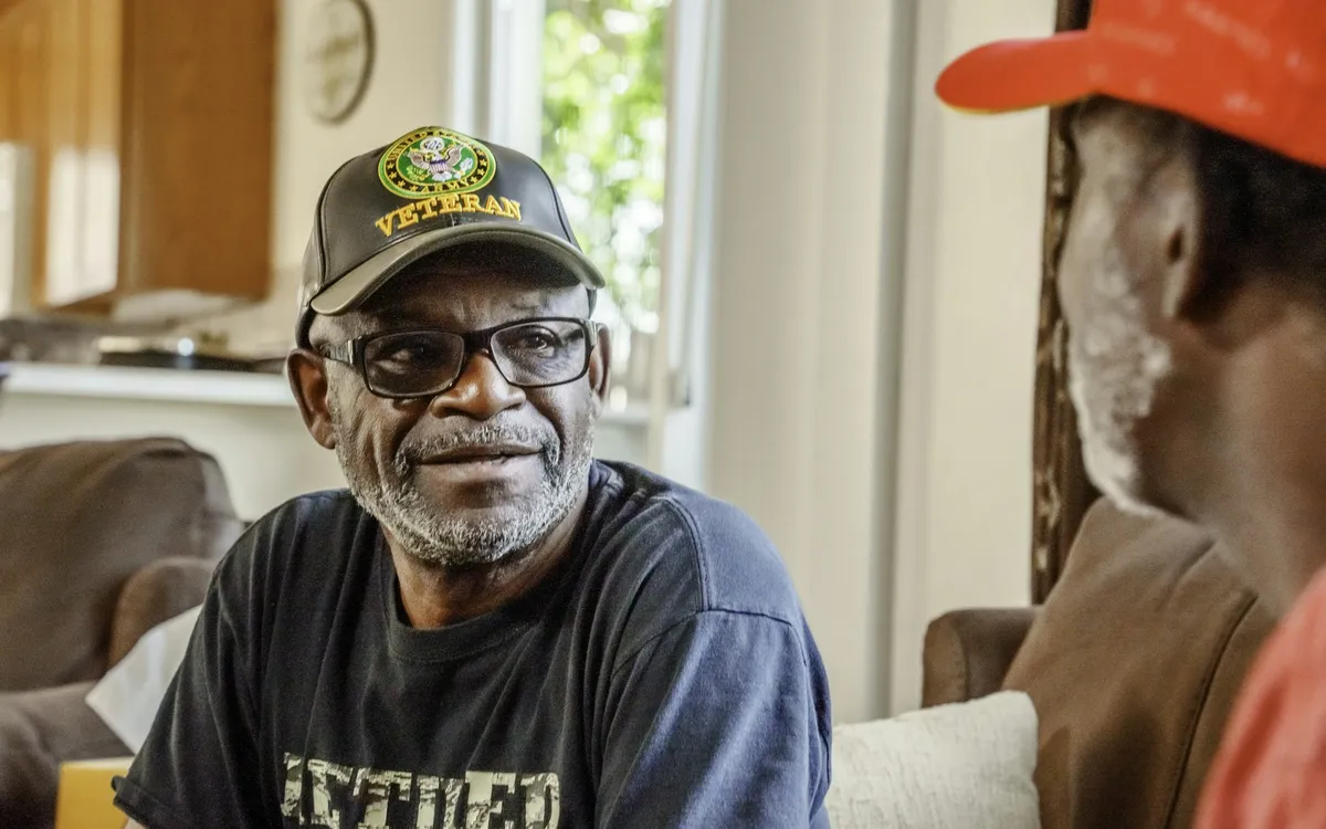 Homem idoso sorrindo durante uma conversa em casa