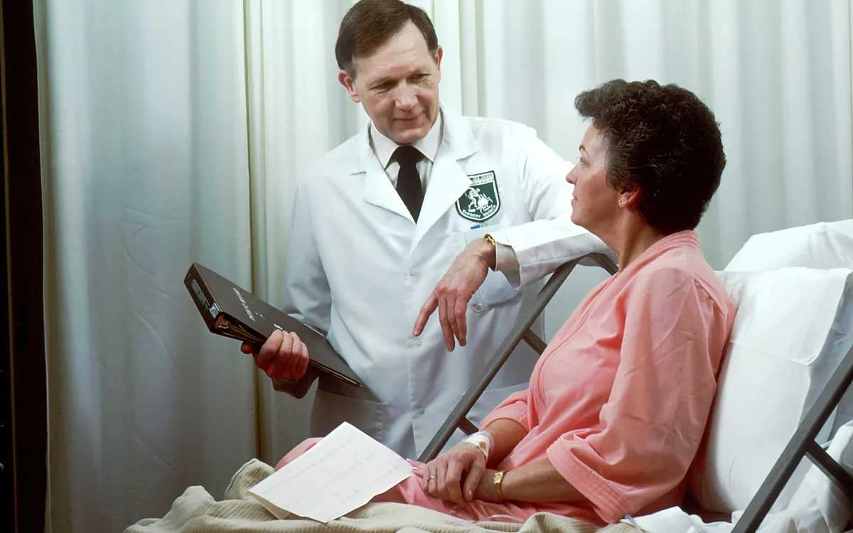 Médico conversando com uma paciente internada no quarto do hospital