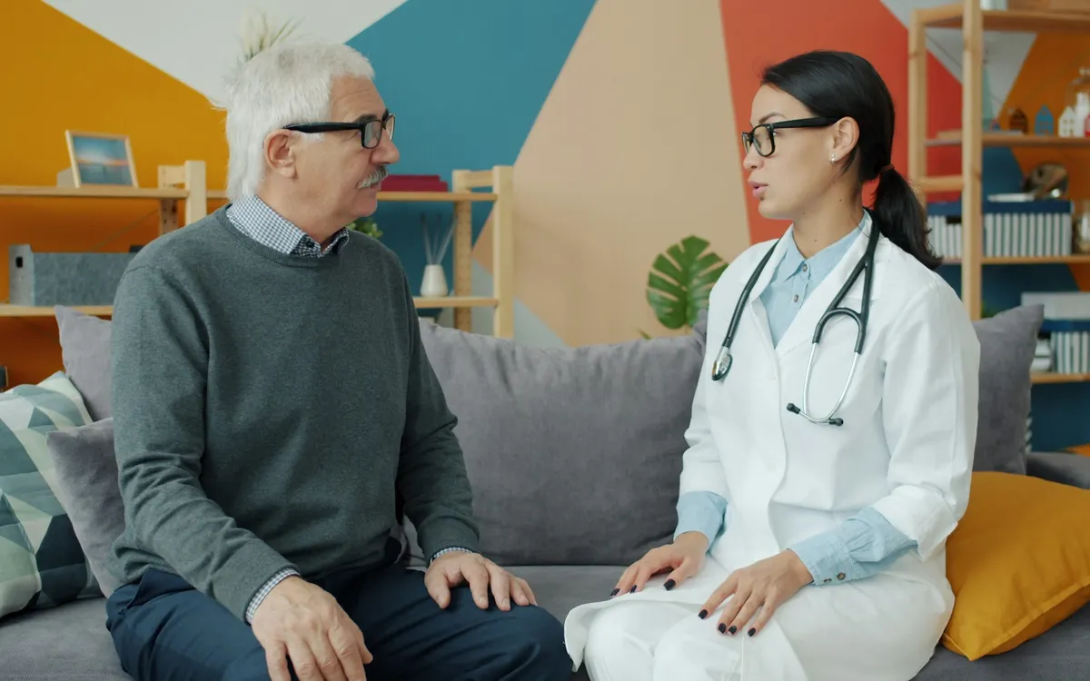 Médico conversando com um paciente idoso