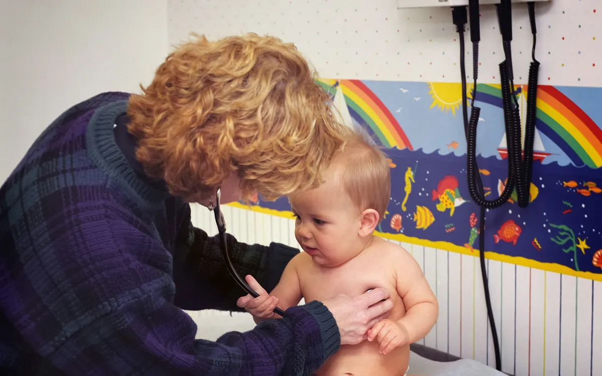 Médica examinando um bebê com o estetoscópio