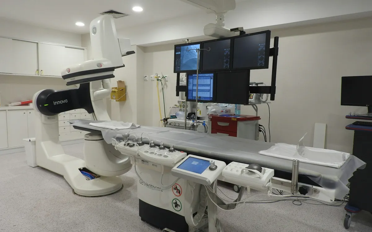 Sala de hemodinâmica com equipamento de imagem e monitores