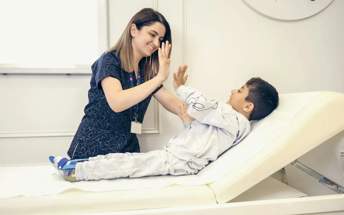 Profissional de saúde batendo a mão com um menino