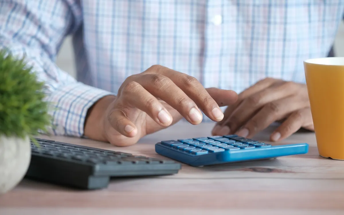 Contador usando calculadora em uma mesa de escritório