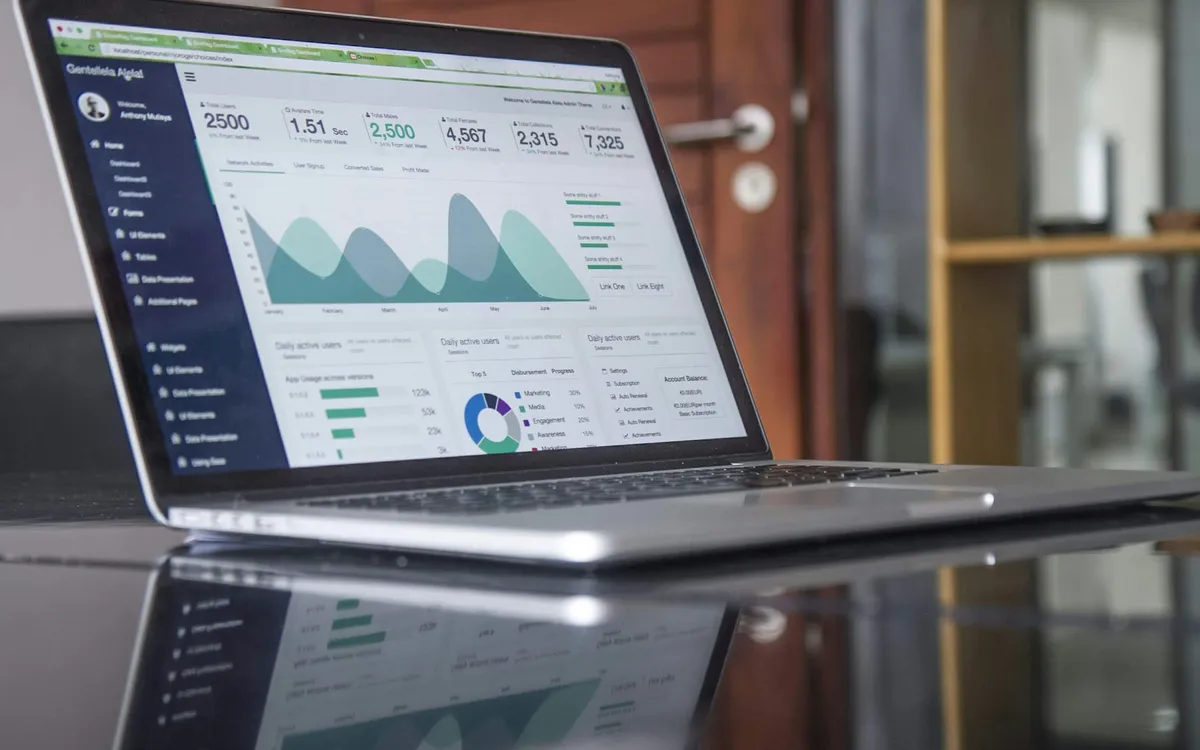 Notebook com gráficos e indicadores financeiros na tela