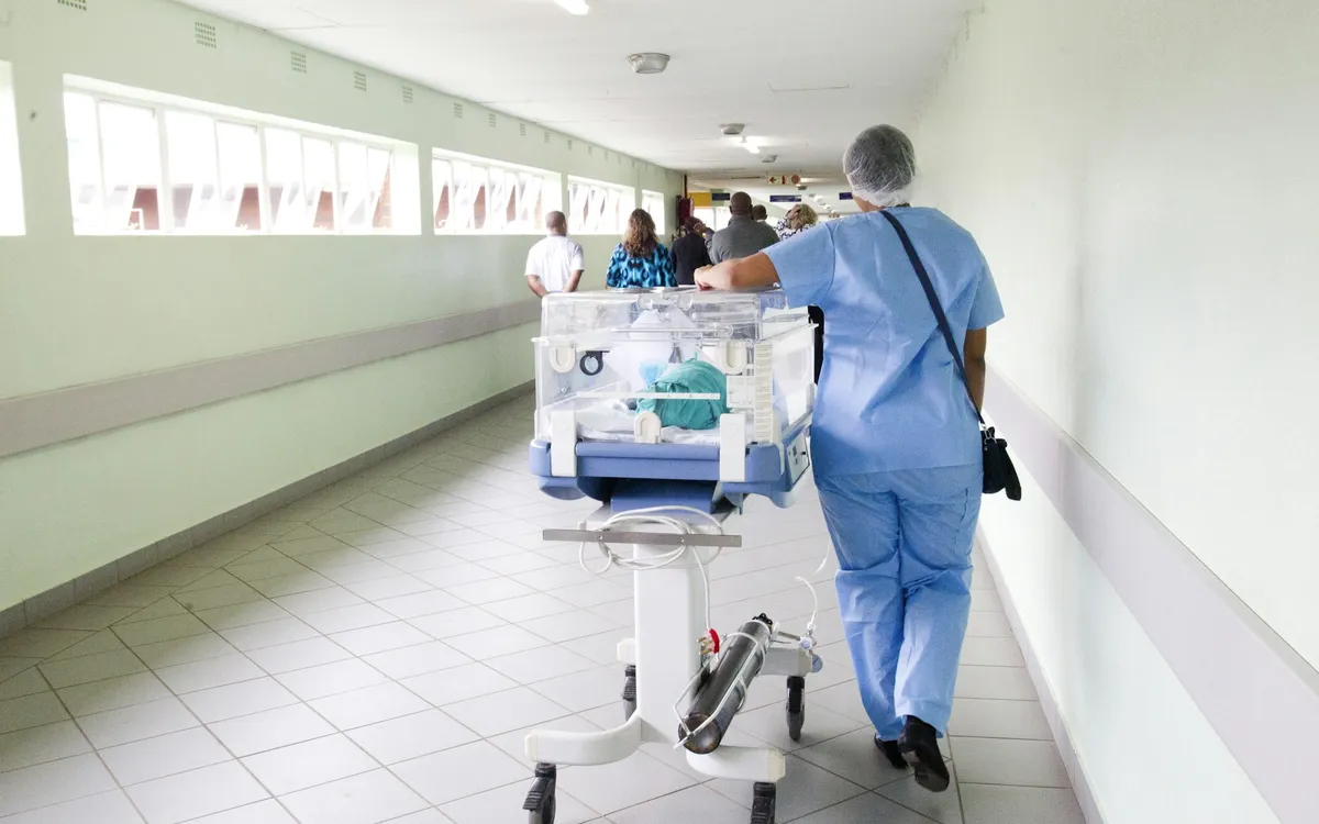 Profissional de enfermagem caminhando no corredor do hospital