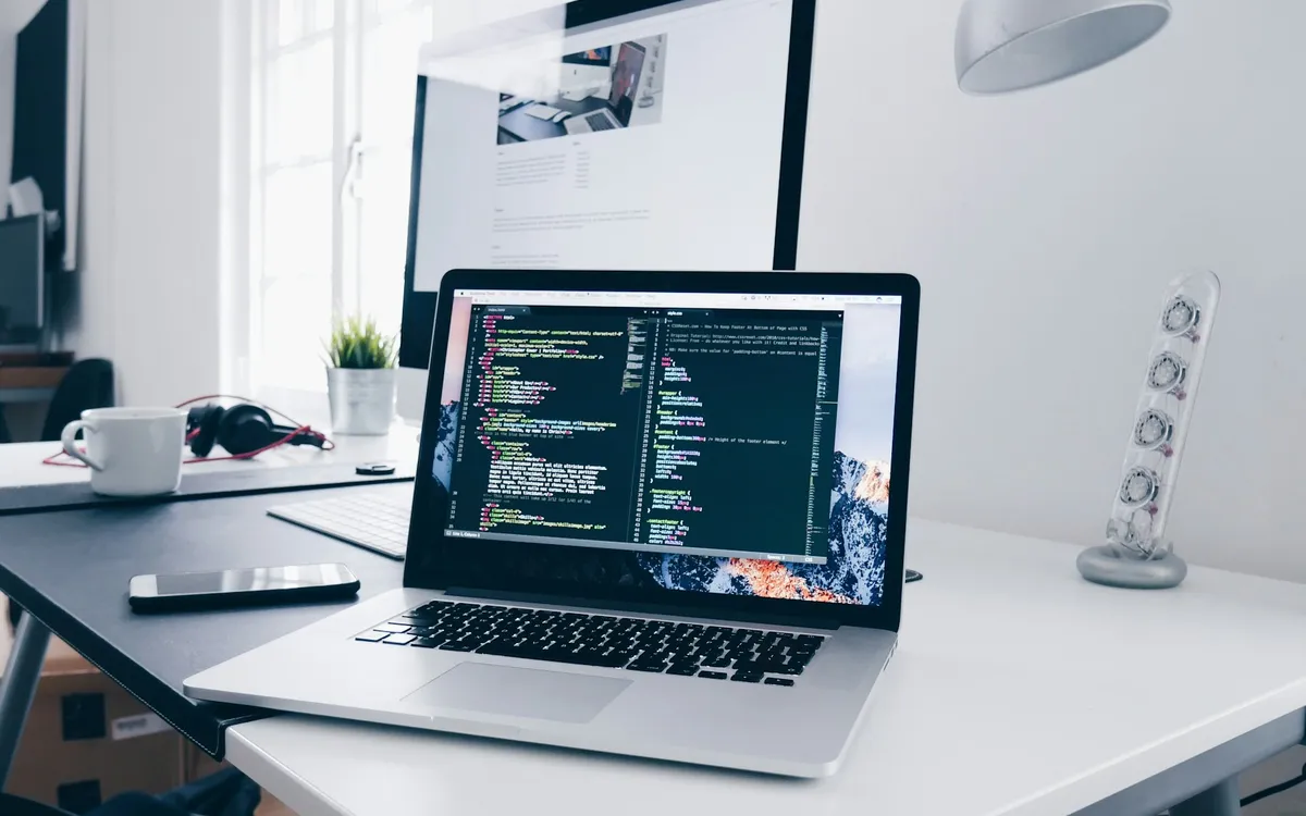 Notebook com código de programação em uma mesa de trabalho