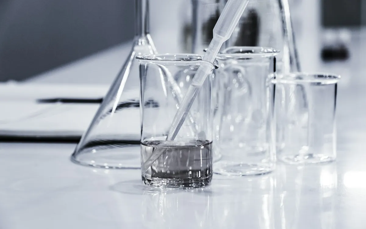 Vidrarias de laboratório com líquido sobre a bancada