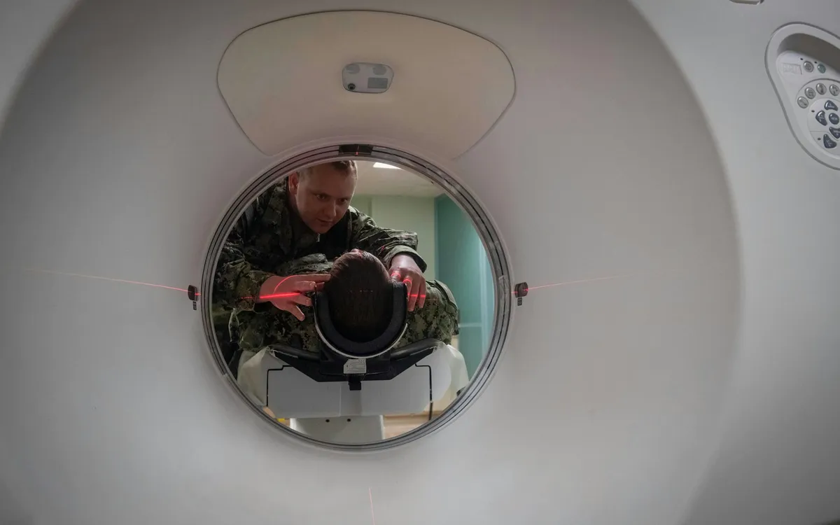 Técnico posicionando um paciente no aparelho de tomografia