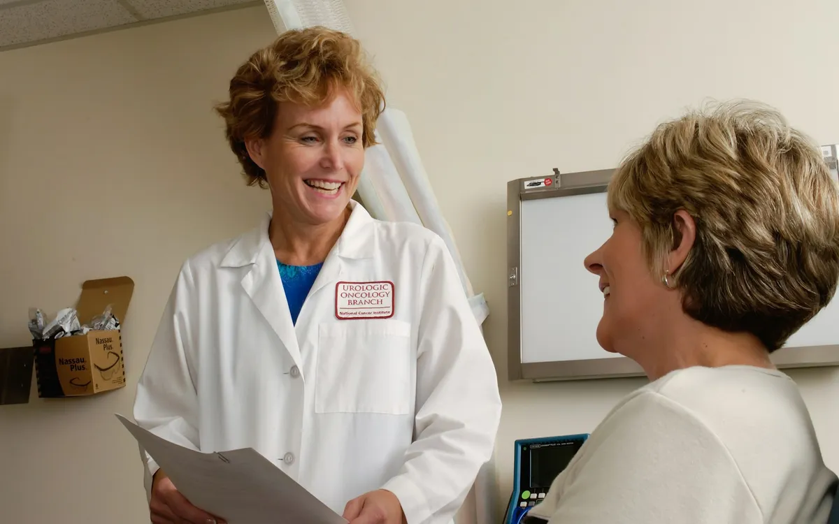 Médico sorridente conversando com paciente no consultório